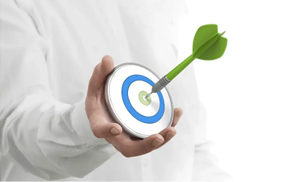 Person holding a target with a green dart in the bullseye